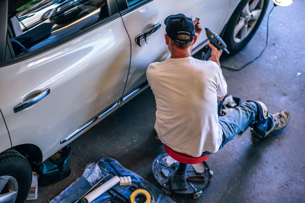 Mobile Mechanic doing auto repairs while sitting down